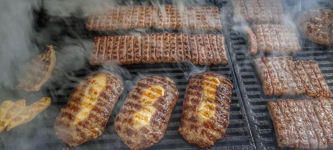 Ćevapi i pljeskavice punjene sirom na roštilju, u dimu