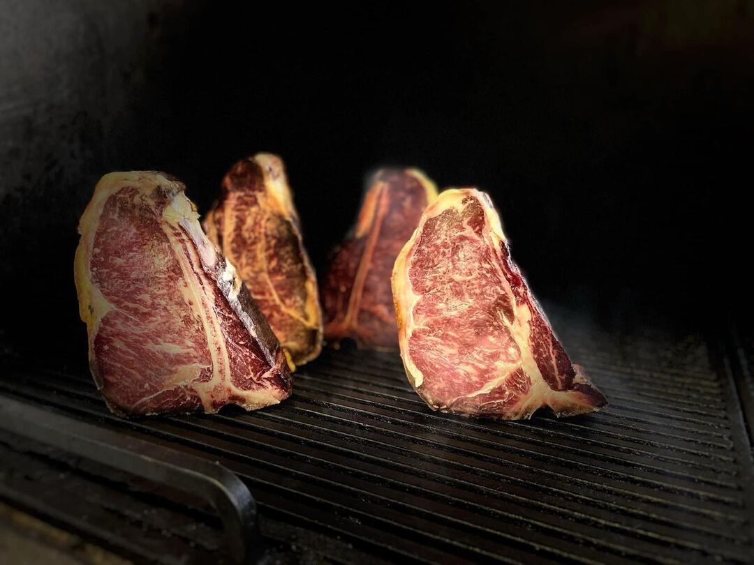 Suho odležani T-bone odresci uspravno na roštilju